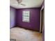 Bedroom with purple walls, a ceiling fan, and a window with views of the backyard at 4014 Oak Stone Dr, Douglasville, GA 30135