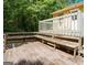 Spacious wooden deck featuring built in benches and wooden railings surrounded by mature trees at 4014 Oak Stone Dr, Douglasville, GA 30135