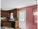 An outdated kitchen features wood cabinets, a small window, and a gray backsplash at 4014 Oak Stone Dr, Douglasville, GA 30135