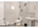 Cozy half bathroom with a pedestal sink, toilet, and decorative mirrors at 1848 Eastmore Ave, Conyers, GA 30094