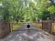 Long paved driveway past gated entrance bordered by mature trees at 45 Surrey Chase Dr, Social Circle, GA 30025