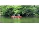 View of two people in a red canoe on a calm lake at 45 Surrey Chase Dr, Social Circle, GA 30025