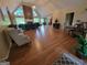 Expansive living room featuring vaulted ceilings, a brick fireplace, and wood flooring throughout the open-concept design at 45 Surrey Chase Dr, Social Circle, GA 30025