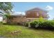 Backyard of brick home features a grassy lawn, greenery, and part of the exterior at 1517 Indian Forest Trl, Stone Mountain, GA 30083