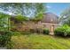Backyard of brick home features a grassy lawn, greenery, and the exterior at 1517 Indian Forest Trl, Stone Mountain, GA 30083