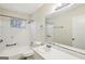 Bathroom with white tile surrounding the tub and a white vanity with a large mirror at 1517 Indian Forest Trl, Stone Mountain, GA 30083