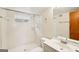Bathroom with a tiled shower and a sink with a mirror and a wooden door at 1517 Indian Forest Trl, Stone Mountain, GA 30083