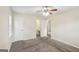 A neutral bedroom has carpeted floors, a ceiling fan, and white trim with two doors at 1517 Indian Forest Trl, Stone Mountain, GA 30083