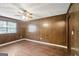 A bedroom features paneled walls, hardwood floors, and a ceiling fan at 1517 Indian Forest Trl, Stone Mountain, GA 30083