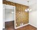 Dining area featuring an exposed brick wall, modern chandelier, and hardwood floors at 1517 Indian Forest Trl, Stone Mountain, GA 30083
