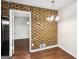 Dining area featuring an exposed brick wall, modern chandelier, and hardwood floors at 1517 Indian Forest Trl, Stone Mountain, GA 30083