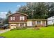 Charming split-level home featuring a brick and wood facade, attached garage, and a well-manicured lawn at 1517 Indian Forest Trl, Stone Mountain, GA 30083