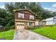 Split-level home featuring a brick and wood facade, attached garage, and concrete driveway at 1517 Indian Forest Trl, Stone Mountain, GA 30083