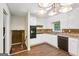 Well-lit kitchen with white cabinets, brick backsplash, laminate countertops, and modern appliances at 1517 Indian Forest Trl, Stone Mountain, GA 30083