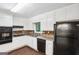 Functional kitchen with white cabinets, black appliances, brick backsplash, and durable countertops at 1517 Indian Forest Trl, Stone Mountain, GA 30083