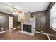 Cozy living room with brick fireplace, wood paneling, ceiling fan, and stairs to the upper level at 1517 Indian Forest Trl, Stone Mountain, GA 30083