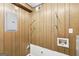 Laundry room with wood paneled walls, exposed plumbing, and a circuit breaker box at 1517 Indian Forest Trl, Stone Mountain, GA 30083