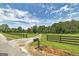 Long gravel driveway with wooden fence on the sides leading to the property and home at 949 Amelia Rd, Locust Grove, GA 30248