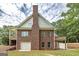 Rear of the home featuring a classic brick design with a large chimney, showcasing the architectural details at 949 Amelia Rd, Locust Grove, GA 30248
