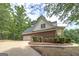 Exterior shot showing a two-car garage, well-kept landscaping, and a brick facade at 949 Amelia Rd, Locust Grove, GA 30248