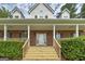 Inviting front porch with brick accents and freshly stained wood stairs, perfect for relaxing at 949 Amelia Rd, Locust Grove, GA 30248