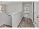 Upstairs hallway with wood flooring, natural light, and views into an adjacent room at 949 Amelia Rd, Locust Grove, GA 30248