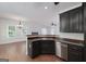 View of kitchen cabinets, stainless dishwasher and view to living and dining areas at 949 Amelia Rd, Locust Grove, GA 30248