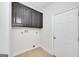 A utility room featuring upper cabinets, tile floors and hookups for washer and dryer at 949 Amelia Rd, Locust Grove, GA 30248