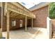 View of the covered patio with exposed beams and brickwork with access door at 949 Amelia Rd, Locust Grove, GA 30248