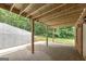 View of the covered patio area with wooden beams and concrete flooring, great for outdoor entertaining at 949 Amelia Rd, Locust Grove, GA 30248