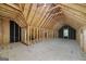 Spacious unfinished attic featuring exposed rafters and beams, and a single window at 949 Amelia Rd, Locust Grove, GA 30248