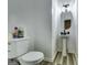 Small bathroom with a toilet, sink, unique light fixture, and gray wood-look floors at 121 Wellbrook Circle Ne, Conyers, GA 30012