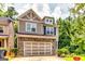 Charming two-story home featuring a stone facade, two-car garage, and well-manicured landscaping at 121 Wellbrook Circle Ne, Conyers, GA 30012