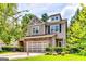 Beautiful two-story home showcasing a stone facade, attached garage, and lush front yard at 121 Wellbrook Circle Ne, Conyers, GA 30012