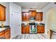 Well-lit kitchen featuring stainless steel appliances, wood cabinets, and gray toned wood-look flooring at 121 Wellbrook Circle Ne, Conyers, GA 30012