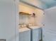 A laundry room featuring a washer, dryer, shelving and gray toned wood-look flooring at 121 Wellbrook Circle Ne, Conyers, GA 30012