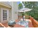 Relaxing back deck with grill, table, umbrella, and access to lush green yard at 20 Knollwood Pl, Covington, GA 30014