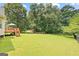 Large grassy yard, stairs leading to back deck, and fenced in backyard at 20 Knollwood Pl, Covington, GA 30014