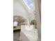 Bathroom soaking tub under a skylight, with an arched opening to the bedroom at 20 Knollwood Pl, Covington, GA 30014