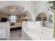 Ensuite bathroom with soaking tub and bedroom view through an arched opening to the bedroom at 20 Knollwood Pl, Covington, GA 30014