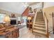 Comfortable living room with a fireplace, high ceilings, adjacent dining area, and a staircase to the upper level at 20 Knollwood Pl, Covington, GA 30014