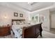 Comfortable main bedroom featuring a tray ceiling, wood-look floors, and an ensuite bath with an arched entry at 20 Knollwood Pl, Covington, GA 30014
