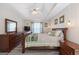 Bright main bedroom with wood-look flooring, ceiling fan, tv, a sleigh bed and decorative wall art at 20 Knollwood Pl, Covington, GA 30014
