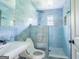 Modern bathroom with striking blue marble tile walls, a walk-in shower, and a white sink and toilet at 24 Shiloh Church Rd, Carrollton, GA 30116