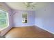 Bedroom featuring light purple walls, hardwood floors, a ceiling fan, and a window offering natural light at 24 Shiloh Church Rd, Carrollton, GA 30116