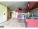 Spacious kitchen area with tile flooring, maroon cabinets, an oven, and connections for appliances at 24 Shiloh Church Rd, Carrollton, GA 30116