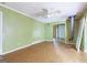 Open living room with green walls, hardwood floors, a ceiling fan, and a view into another room at 24 Shiloh Church Rd, Carrollton, GA 30116