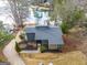 Aerial view of house with modern gray roof, stone accents, manicured lawn, and lake access at 1190 Plantation Dr, Villa Rica, GA 30180
