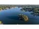 Scenic aerial shot of a lake featuring a small island with lush trees and a dock at 1190 Plantation Dr, Villa Rica, GA 30180