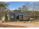 Contemporary home with stone detailing, tidy landscaping, and serene lakeside setting at 1190 Plantation Dr, Villa Rica, GA 30180